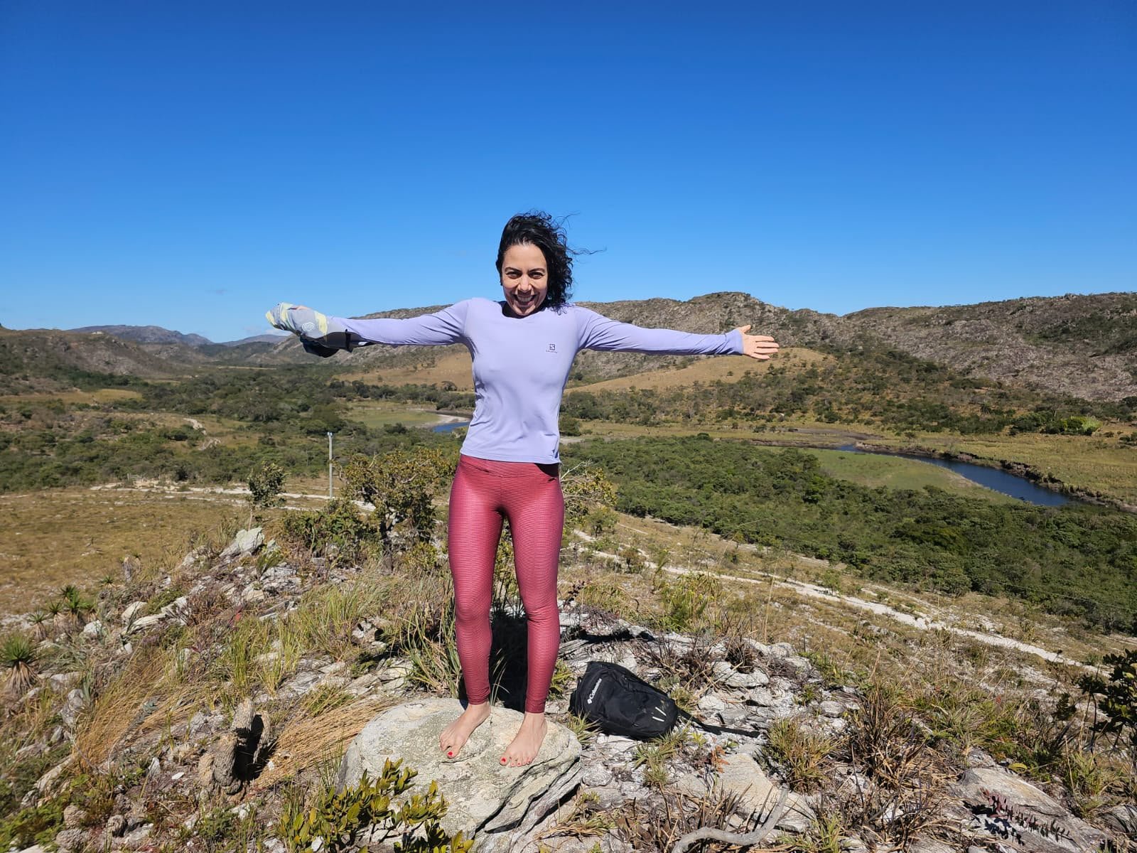 Rachel de braços abertos no alto de uma montanha